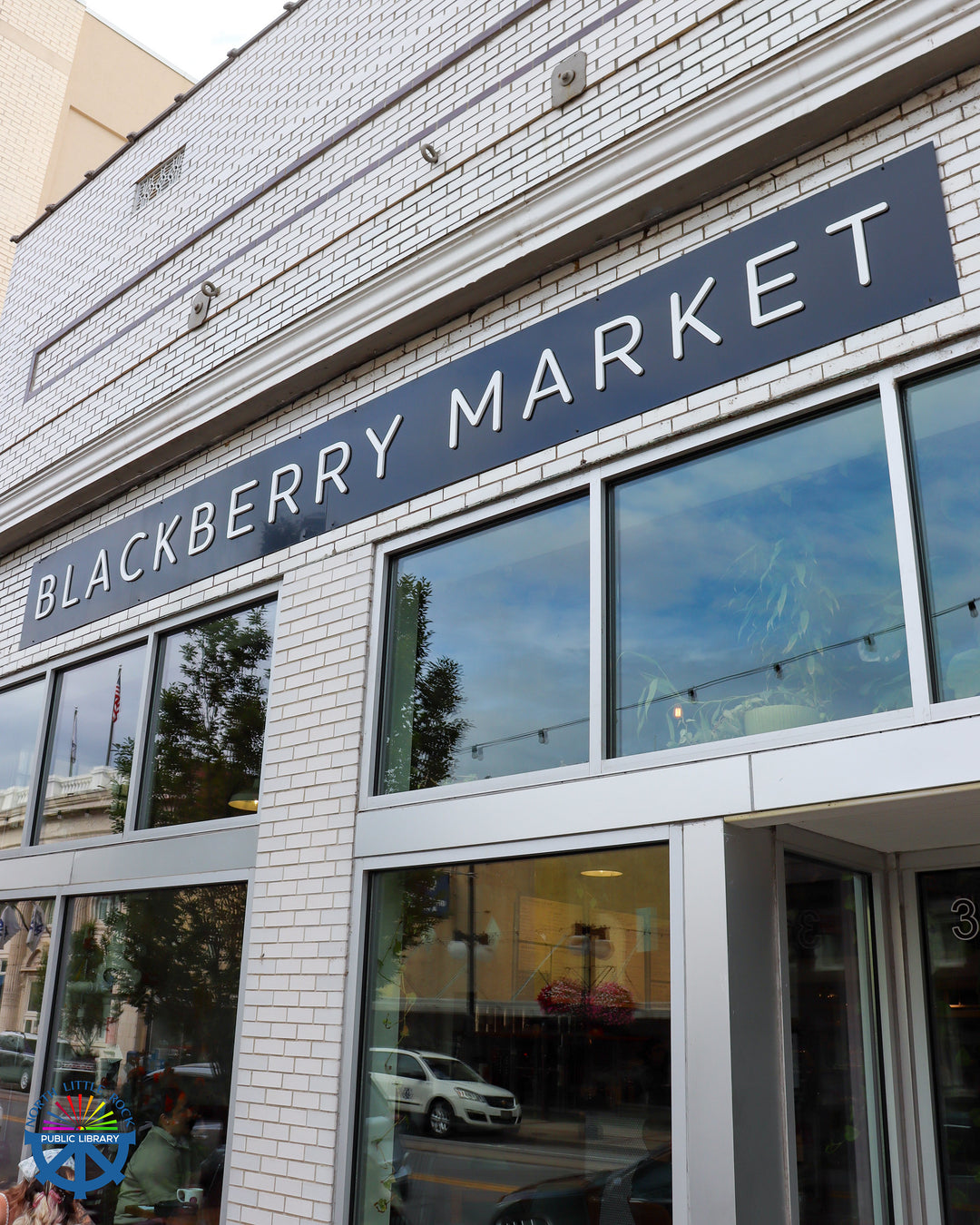 Blackberry Market building with large glass windows and white brick.