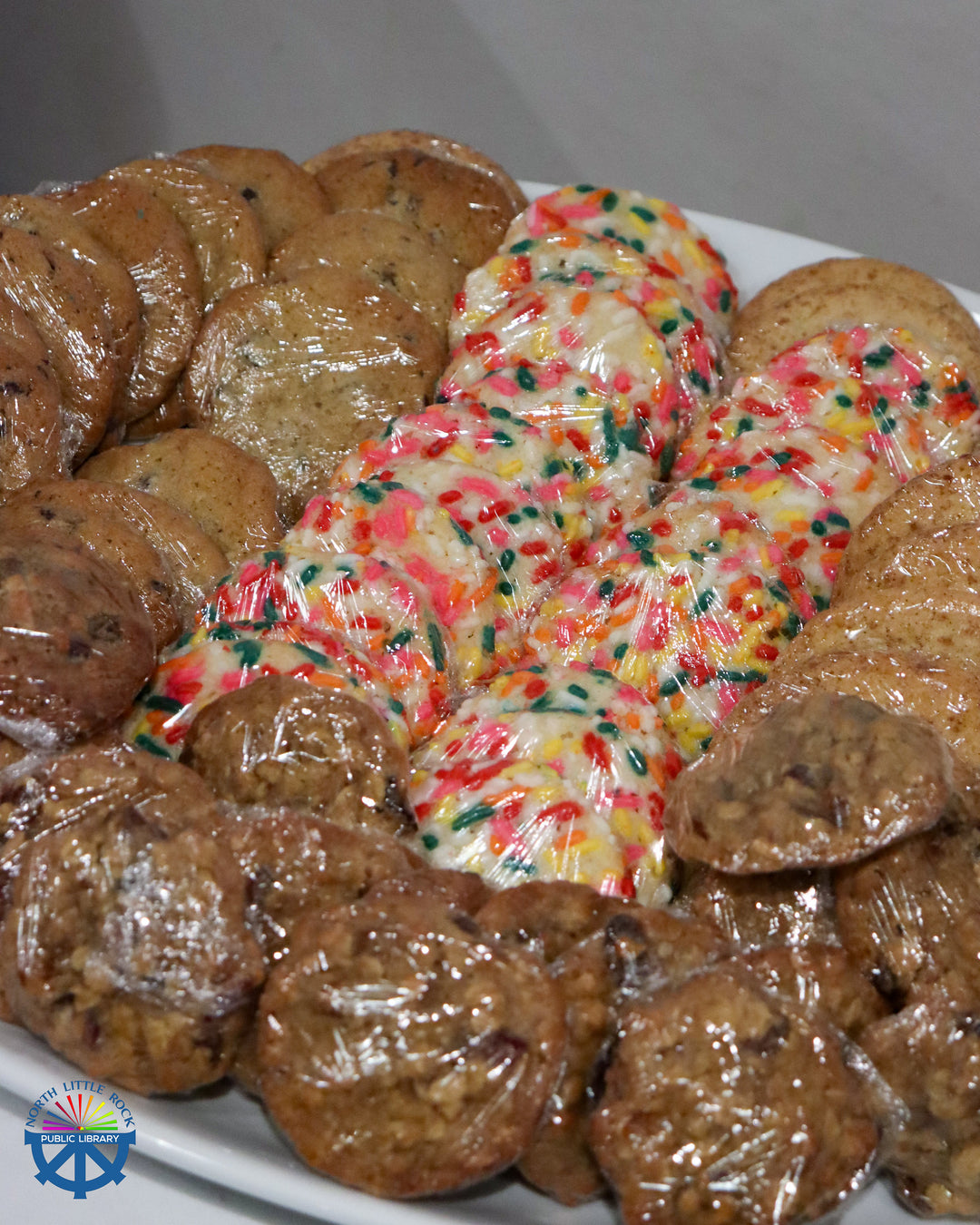 Assorted cookies on a plate with a focus on a colorful cookie in the center.