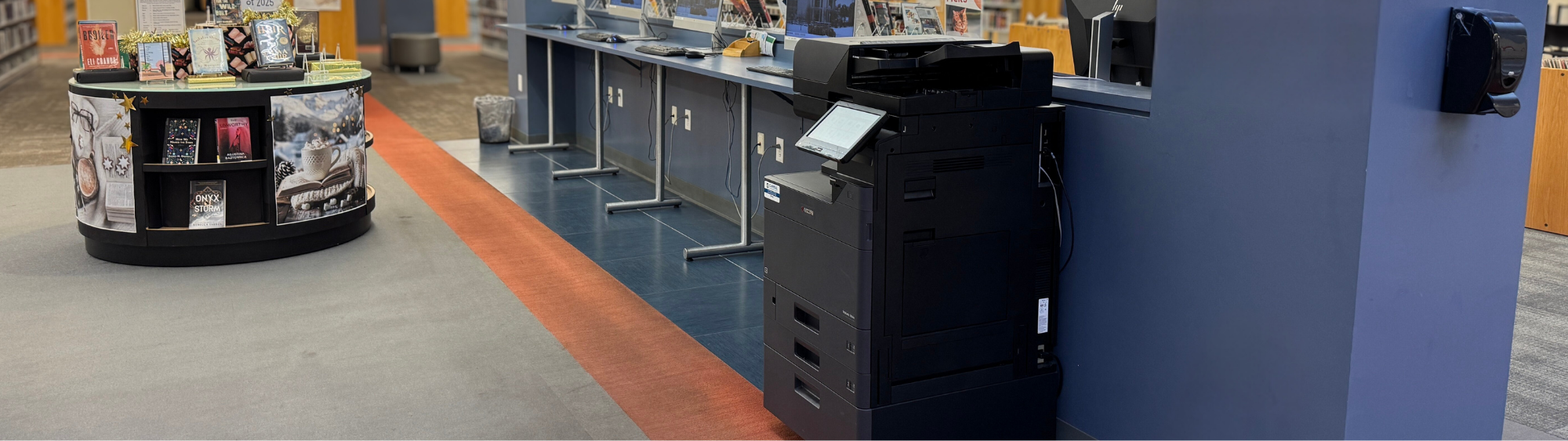 Wireless printing station in the library near a bank of computers and book displays