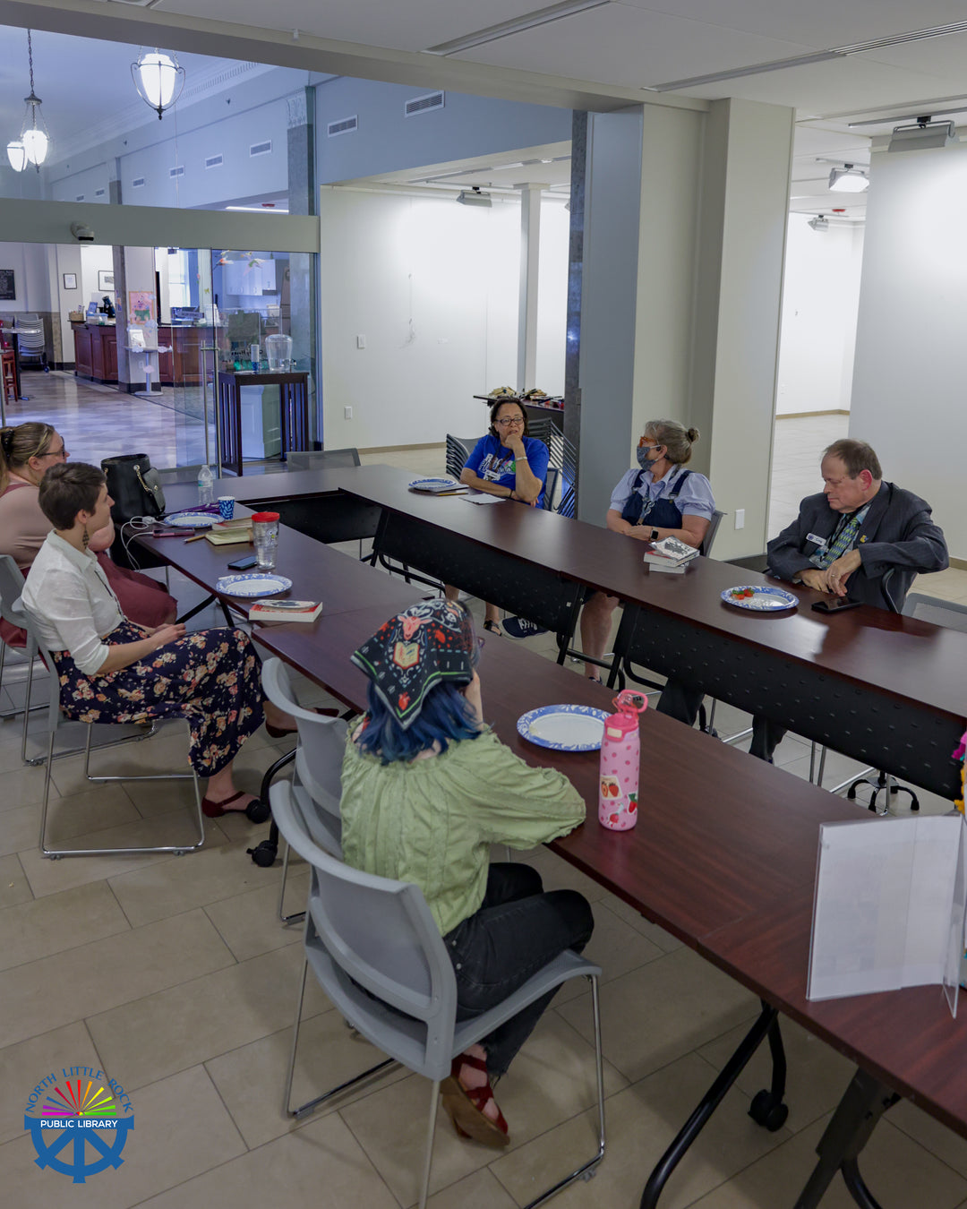 People sitting at tables discussing a book.