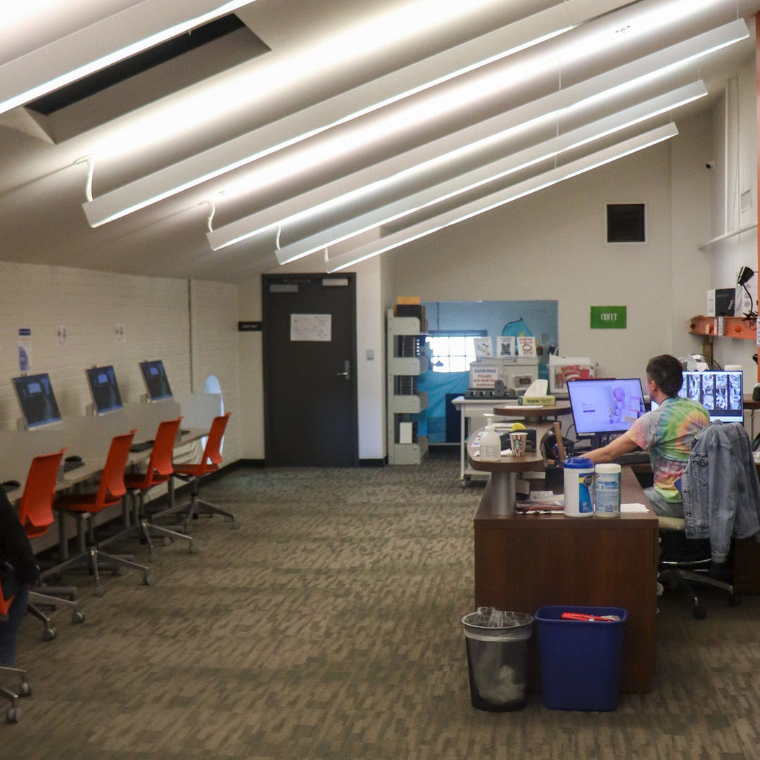 A computer lab with carpet and a slanted ceiling.