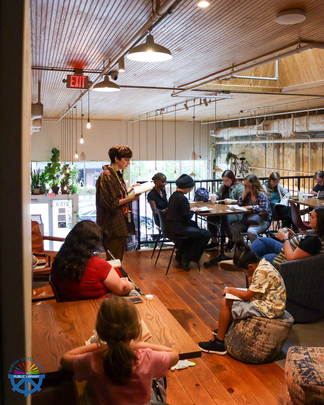 People sitting and reading in Blackberry Market's modern cafe with wooden floors and large windows.