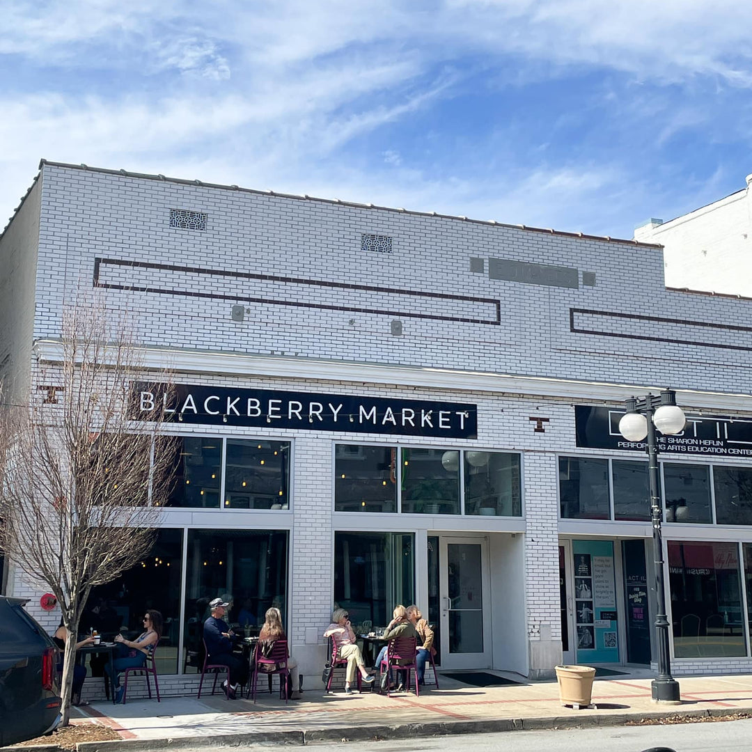 White brick building with 'Blackberry Market' sign on NLR's Main St. on a clear day