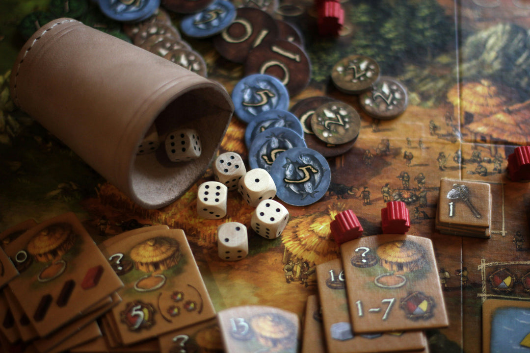 Dice, tockens, cards, and more on top of a board game.