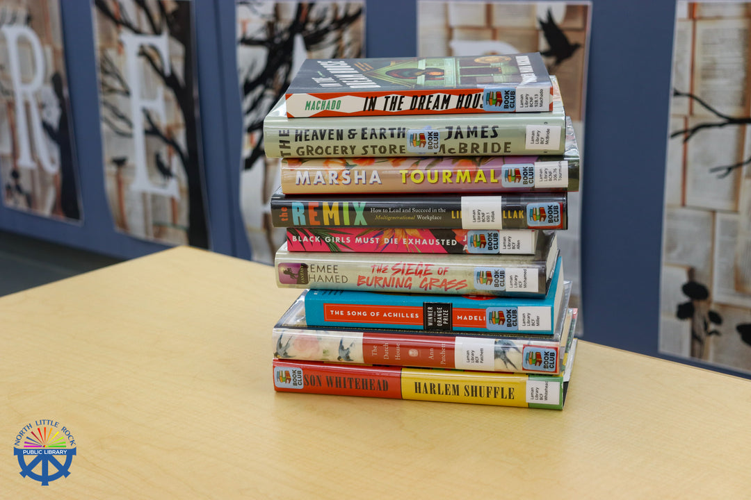 A stack of books on a wooden table.