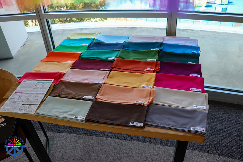 Colorful pieces of fabric used for color analysis arranged on a table.