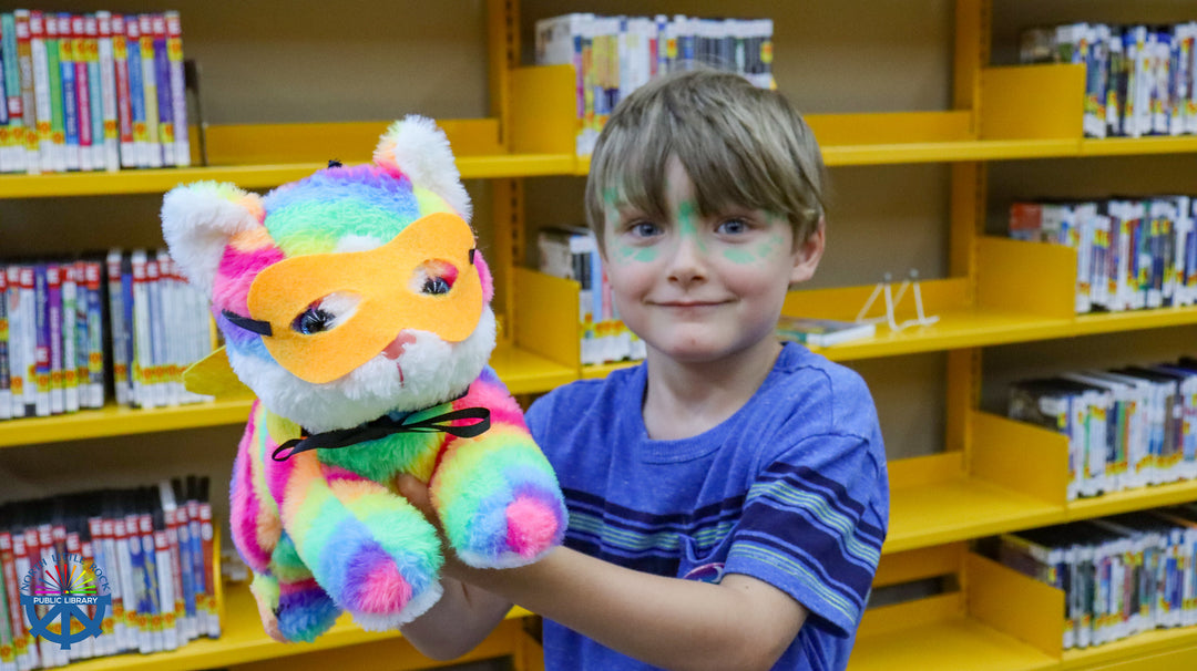 Child with fresh cosplay face painting  holding a colorful plush toy with superhero mask .