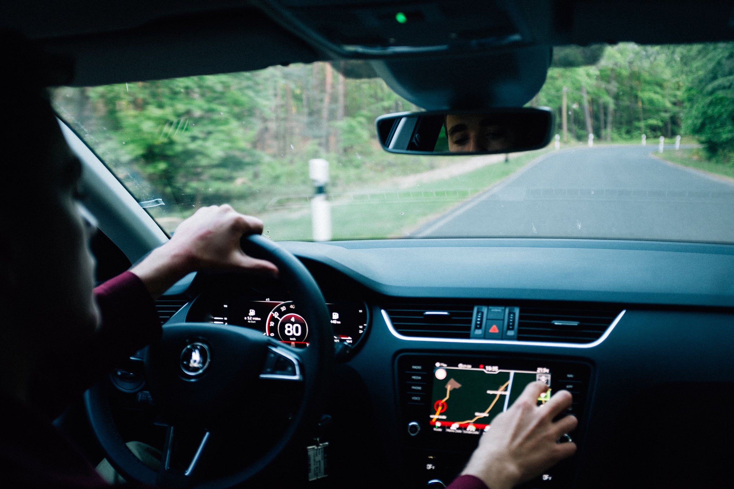 Inside a car with a driver holding the wheel.