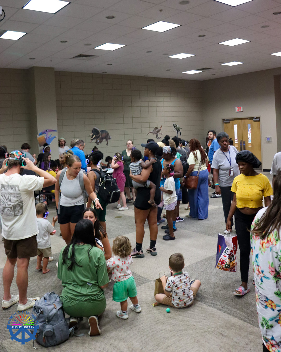 People stand and sit in the Laman Lecture Hall as they enjoy the End of Summer party.
