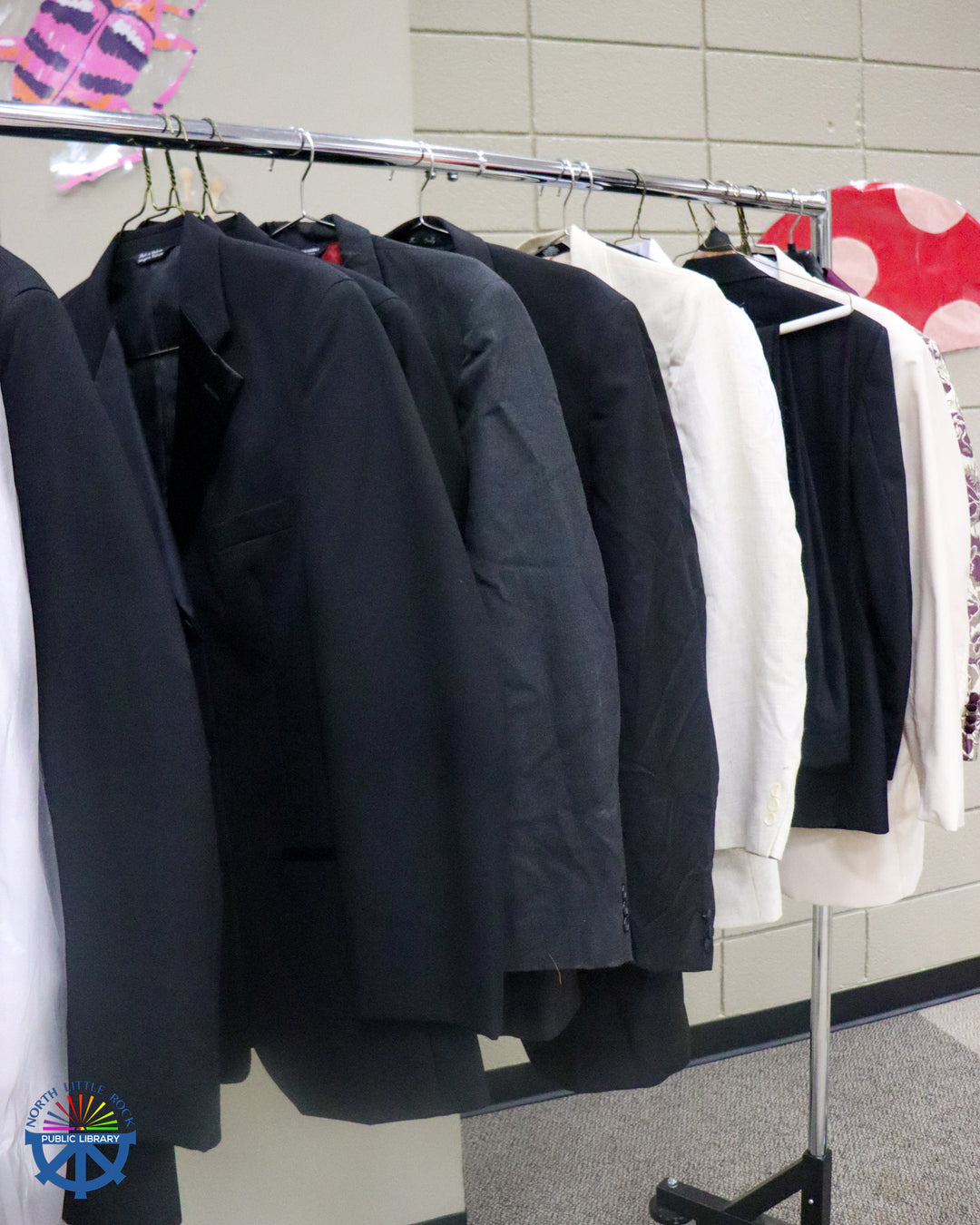 An assortment of black, grey, and white suit coats.