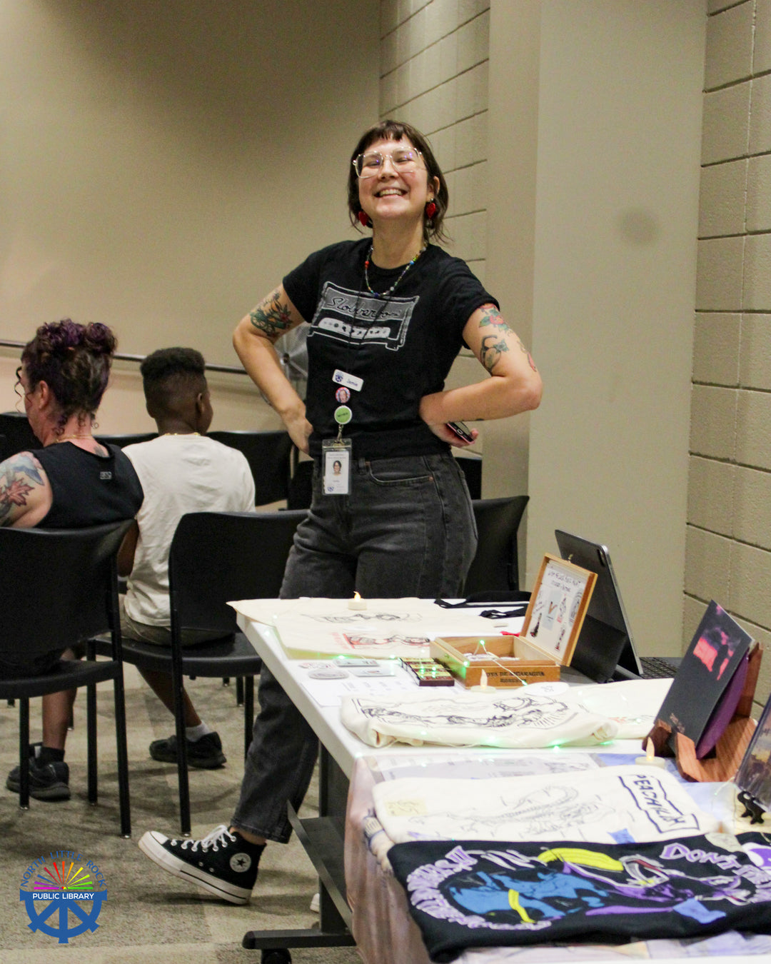 Event organizer Jamie stands by the merch table.