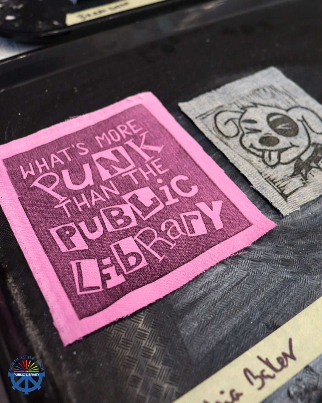 A close-up of a block printed patch reading What's More Punk Than the Public Library.
