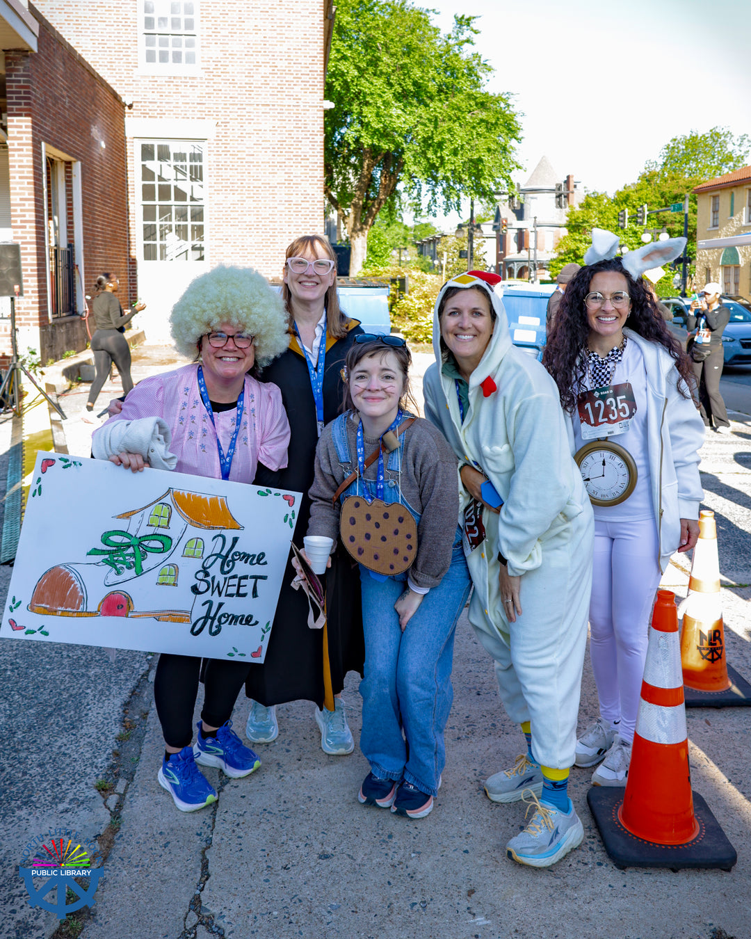 A group of people dressed as book characters pose for a group photo.