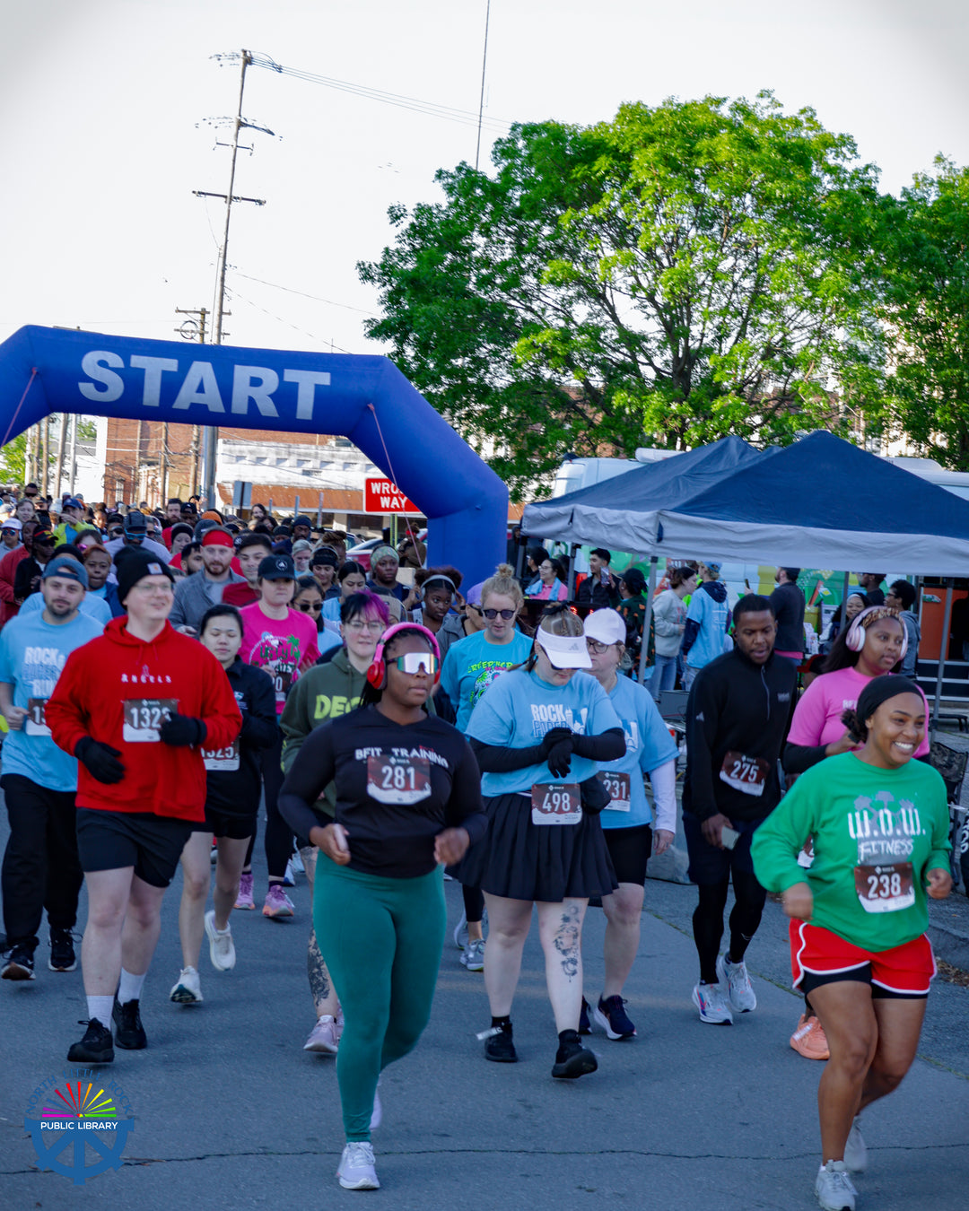 Runners run through a starting arch to begin their race