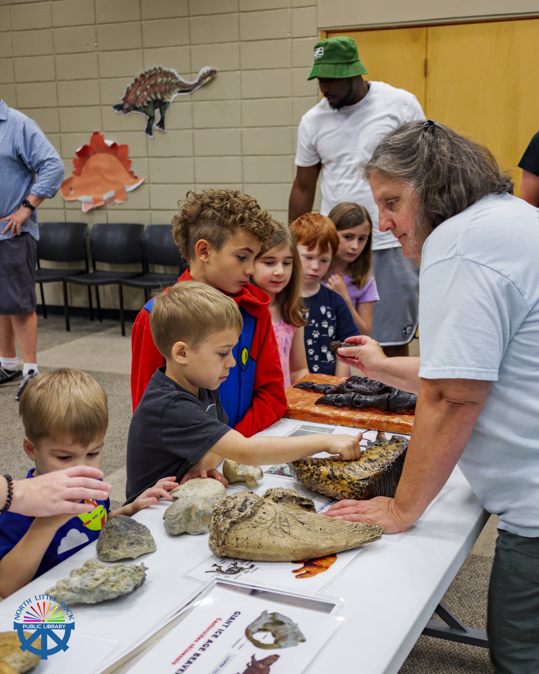 Arkansas Geologist, Angela Chandler shows a group of children replica and real fossils found in Arkansas.