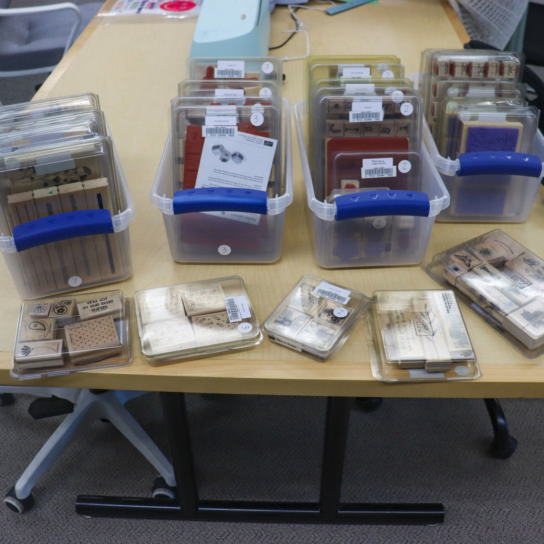 Assorted stamps in boxes on a wooden table.