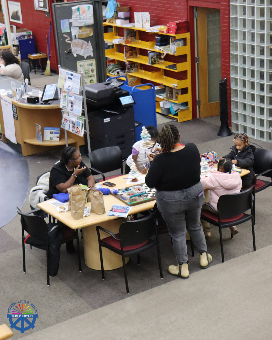 Drienne demonstrating how to make a craft with paper.