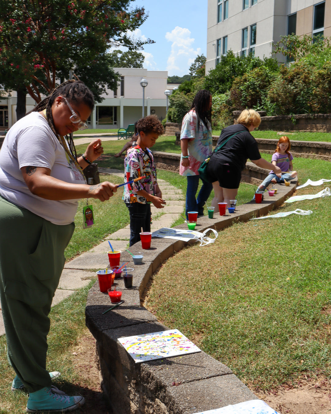 Drienne shows tweens how to splatter paint in the Laman Plaza.