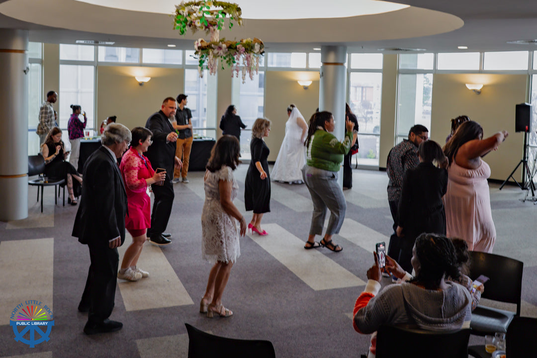 Wedding participants and staff line-dancing to music.