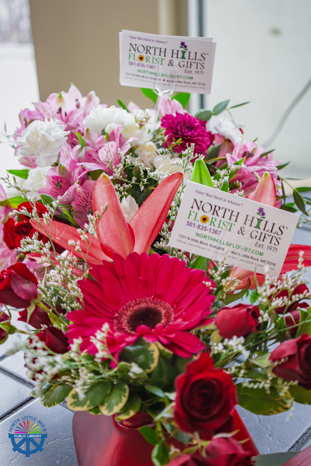 Colorful flower arrangements in red cases, generously donated by North Hills Florist & Gifts.