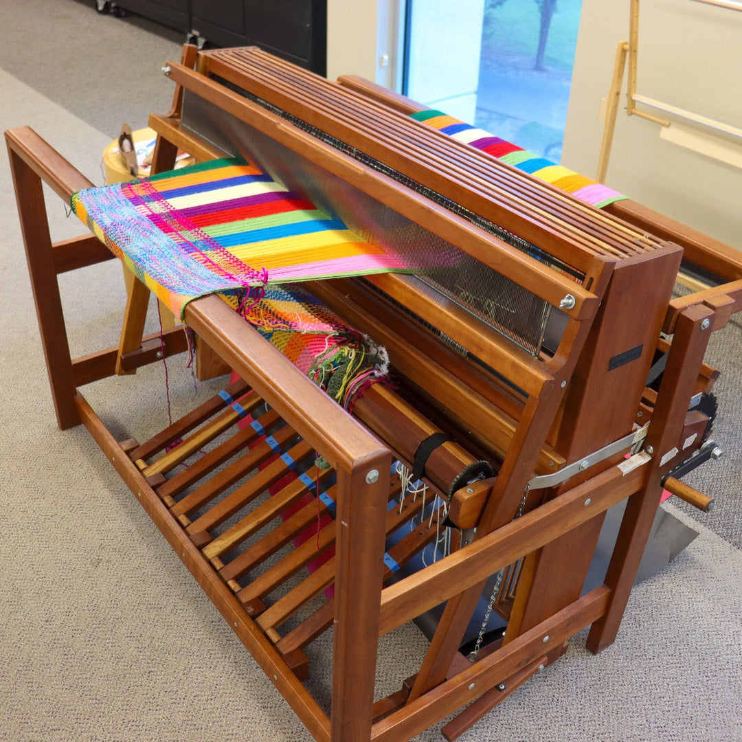 A large wooden loom used to create colorful tapestries.