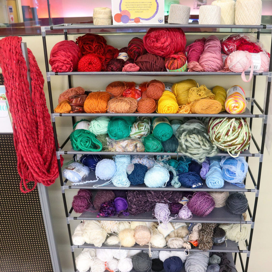 Colorful yarn on narrow shelves.